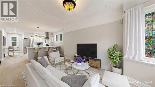 Open-concept living area featuring light wood-finish flooring and a decorative stained-glass window - 59 Longwood Road N, Hamilton, ON - Indoor Photo Showing Other Room