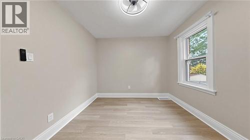 Light-filled interior space with wood-finish flooring, neutral wall paint, and white trim - 59 Longwood Road N, Hamilton, ON - Indoor Photo Showing Other Room