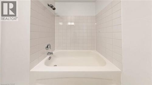 White subway tile shower surround with integrated bathtub and chrome fixtures - 59 Longwood Road N, Hamilton, ON - Indoor Photo Showing Bathroom