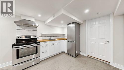 Compact kitchen featuring stainless steel appliances, including a range and refrigerator - 59 Longwood Road N, Hamilton, ON - Indoor Photo Showing Kitchen With Stainless Steel Kitchen