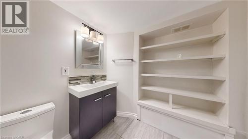 Modern vanity with a rectangular basin, chrome faucet, and glass tile backsplash - 59 Longwood Road N, Hamilton, ON - Indoor With Storage