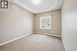 Neutral-toned room with a tray ceiling and a single window - 