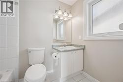 Bathroom featuring a single vanity with a cultured marble countertop, white cabinetry, and a framed mirror with a four-bulb light fixture - 
