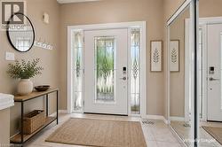 Entryway featuring a white door with decorative glass inserts, flanking sidelights, and overhead transom window - 
