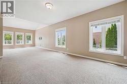 Expansive room featuring vaulted ceilings, light-toned wall paint, and patterned carpeting - 