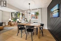 Dining area featuring wood-finish flooring, a decorative ceiling medallion, and a modern chandelier - 