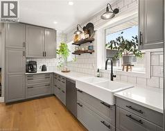 Modern kitchen featuring light wood-finish flooring and a subway tile backsplash - 
