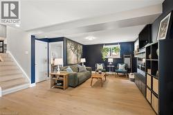 Spacious living area featuring light wood-finish flooring, recessed lighting, and a built-in media console with storage - 
