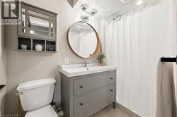 Bathroom with a gray vanity, integrated sink, and an overhead mirror - 
