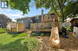 Multi-level wooden deck with a built-in hot tub enclosure and privacy screens - 