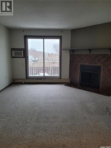 205 306 Perkins Street, Estevan, SK - Indoor Photo Showing Living Room With Fireplace