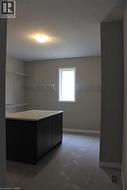Spacious walk-in closet featuring a central island with dark cabinetry and a light-colored countertop - 
