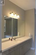 Long vanity featuring an integrated sink, brushed nickel faucet, and wood-finish cabinetry - 