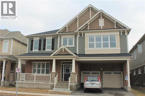 Two-story residence featuring a covered front porch with white railings, brick columns, and stone accents - 31 Pointer Street Unit# Main Floor, Cambridge, ON - Outdoor With Facade