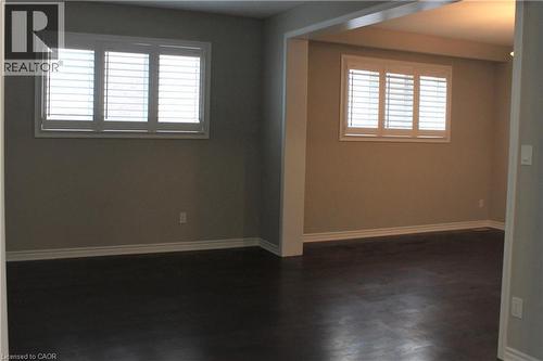 Spacious interior featuring dark wood-finish flooring, light neutral-toned walls, white baseboards, and white window shutters - 31 Pointer Street Unit# Main Floor, Cambridge, ON - Indoor Photo Showing Other Room