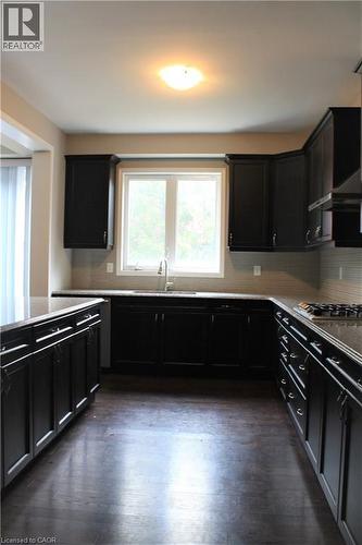 Kitchen featuring dark wood-finish cabinetry and dark countertops - 31 Pointer Street Unit# Main Floor, Cambridge, ON - Indoor Photo Showing Kitchen With Double Sink