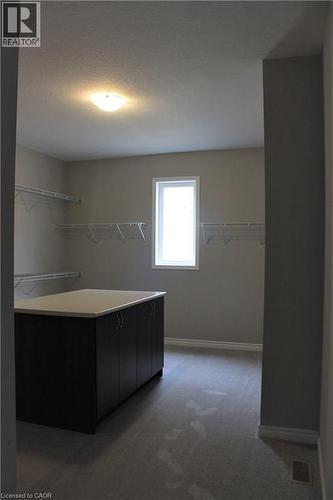 Spacious walk-in closet featuring a central island with dark cabinetry and a light-colored countertop - 31 Pointer Street Unit# Main Floor, Cambridge, ON - Indoor