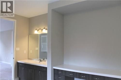 Vanity area featuring a built-in countertop, undermount sink, and a multi-bulb light fixture - 31 Pointer Street Unit# Main Floor, Cambridge, ON - Indoor Photo Showing Bathroom
