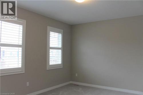 Neutral-toned room featuring two windows with white plantation shutters, light gray wall paint, white baseboards, and wall-to-wall carpeting - 31 Pointer Street Unit# Main Floor, Cambridge, ON - Indoor Photo Showing Other Room