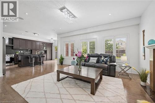 Open-concept living space featuring wood-finish flooring, recessed lighting, and a crystal chandelier - 145 Redtail Street, Kitchener, ON - Indoor Photo Showing Living Room