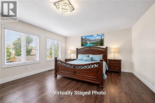 Spacious room featuring rich wood-finish flooring, light-toned walls, and a contemporary ceiling light fixture - 145 Redtail Street, Kitchener, ON - Indoor Photo Showing Bedroom