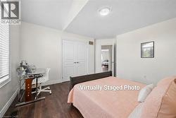 Bedroom with wood-finish flooring, white painted walls, and a window with blinds - 