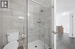 Bathroom featuring a glass-enclosed shower with light gray subway tile surround and a chrome shower head - 