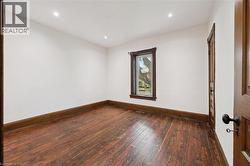 Room featuring wood-finish flooring, white walls, and recessed lighting - 