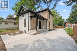 Concrete patio area featuring a covered porch with black columns. - 