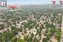 Aerial perspective showcasing a residential area with a mix of single-family homes and multi-story buildings, surrounded by mature trees - 