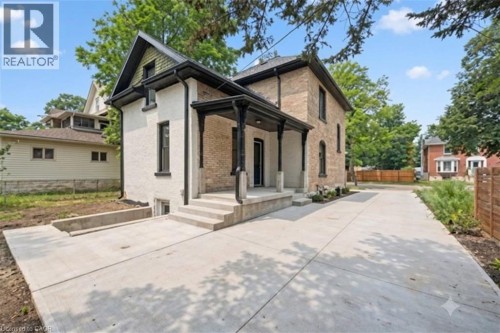 Concrete patio area featuring a covered porch with black columns. - 245 Lowther Street S, Cambridge, ON - Outdoor