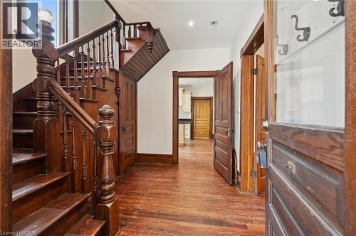 Foyer featuring wood-finish flooring, a traditional wood staircase with balusters, wood paneling, - 245 Lowther Street S, Cambridge, ON - Indoor Photo Showing Other Room