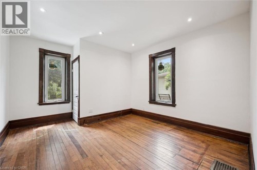 Interior room featuring hard wood flooring, white walls, dark wood trim, recessed lighting, and two windows - 245 Lowther Street S, Cambridge, ON - Indoor Photo Showing Other Room