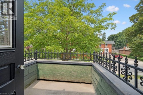 Balcony featuring black wrought iron railing, concrete flooring, and green shingle siding - 245 Lowther Street S, Cambridge, ON - Outdoor