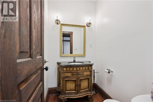 Powder room featuring a detailed wood-finish vanity with a dark countertop and integrated sink - 245 Lowther Street S, Cambridge, ON - Indoor Photo Showing Bathroom