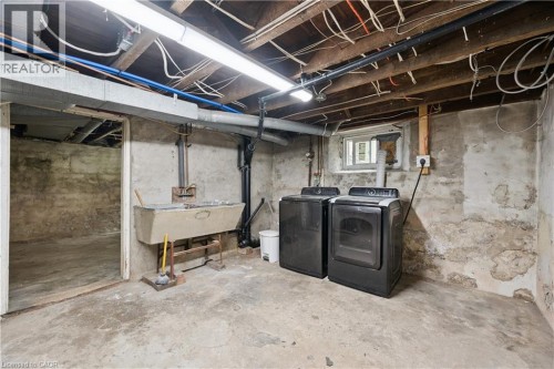 Basement utility area featuring a concrete floor, exposed wood ceiling joists, and a utility sink - 245 Lowther Street S, Cambridge, ON - Indoor Photo Showing Basement