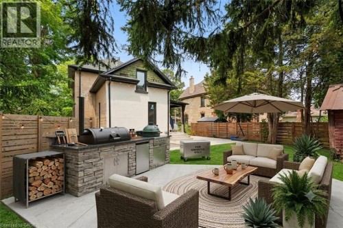 Expansive concrete patio featuring a built-in stone outdoor kitchen with integrated appliances - 245 Lowther Street S, Cambridge, ON - Outdoor