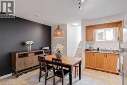 Kitchen area featuring light wood-finish cabinetry, a double basin stainless steel sink, and a laminate countertop - 
