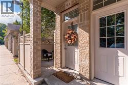 Entryway featuring stone facade, a solid panel door with upper window, and a separate full-light grid door - 