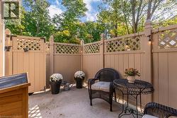 Enclosed patio featuring durable composite fencing with lattice accents, a private gated entrance, and a concrete surface - 