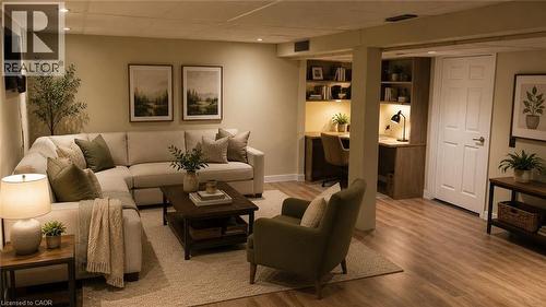 Finished living space featuring wood-finish flooring, recessed lighting, and wall-mounted shelving - 274 East 38Th Street, Hamilton, ON - Indoor Photo Showing Living Room