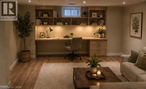 Integrated wood-finish desk with task lighting, built-in shelving, recessed ceiling lighting, wood-finish flooring, and a window - 274 East 38Th Street, Hamilton, ON - Indoor Photo Showing Living Room
