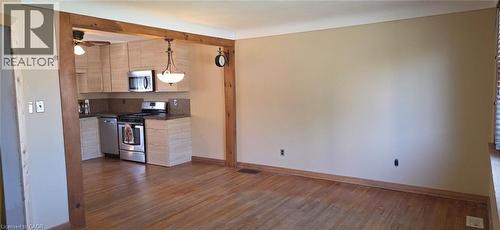 Hardwood flooring throughout, featuring a kitchen with light wood-finish cabinetry, stainless steel appliances, and a pendant light fixture - 274 East 38Th Street, Hamilton, ON - Indoor