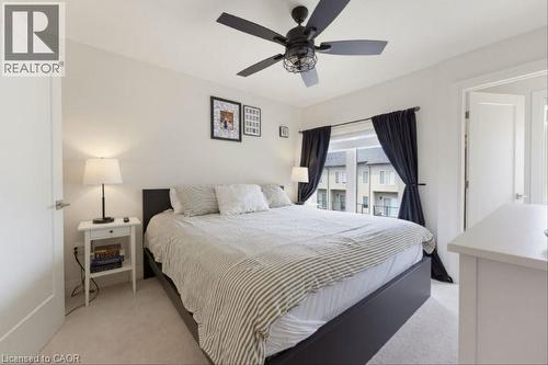Carpeted room with a ceiling fan light fixture, white walls, and a window featuring black curtains - 16 Raspberry Lane, Hamilton, ON - Indoor Photo Showing Bedroom