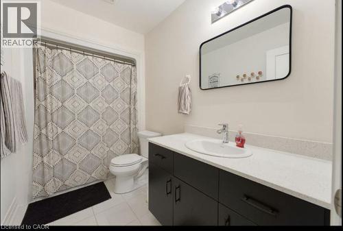 Bathroom featuring a black vanity with white countertop, undermount sink, and a framed rectangular mirror - 16 Raspberry Lane, Hamilton, ON - Indoor Photo Showing Bathroom