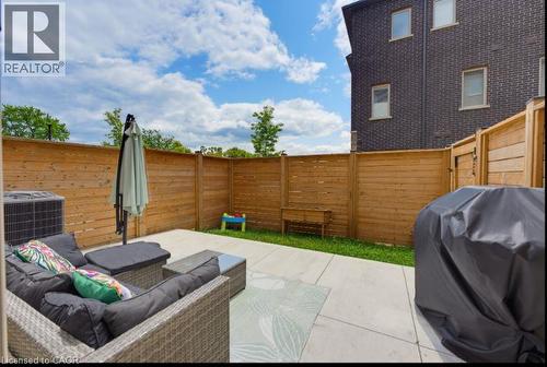 Private backyard featuring a concrete patio and a lush grass area - 16 Raspberry Lane, Hamilton, ON - Outdoor With Exterior