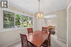 Light-filled room featuring a large multi-pane window, crown molding, and a decorative ceiling fixture - 