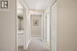 Hallway with neutral wall tones and light-colored carpeting - 