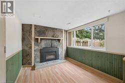 Stone veneer fireplace with a black insert, complemented by a light wood mantel - 