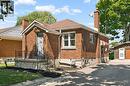 Brick exterior residence featuring a front entry porch with black railings, a paved driveway, and a detached garage with an overhead door - 714 Frederick Street, Kitchener, ON  - Outdoor 